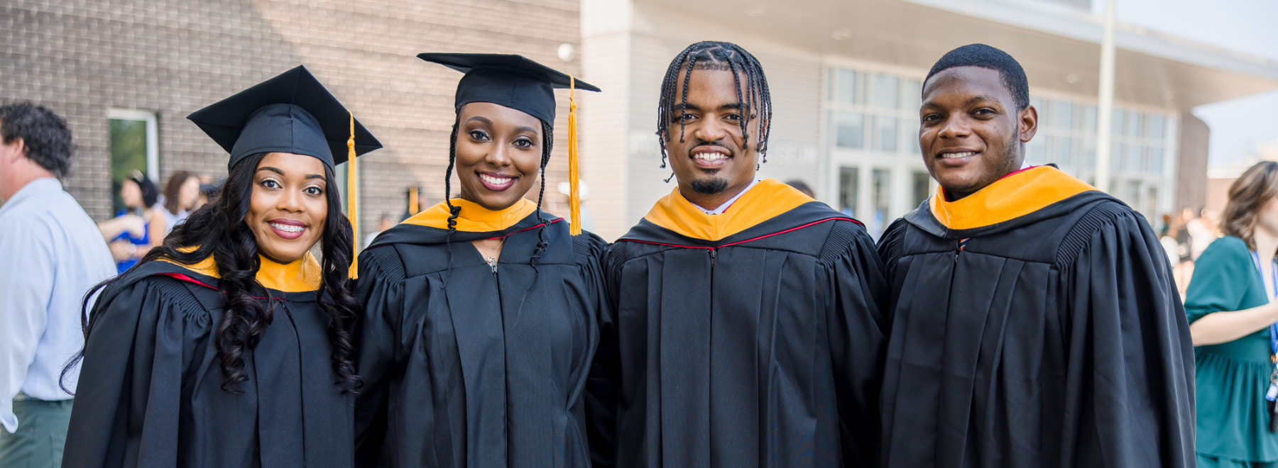 Four UMMC Graduates pose for a photo at Commencement